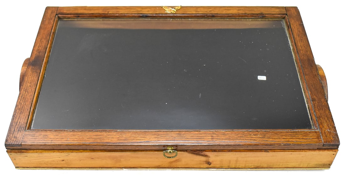 WOODEN DISPLAY CASE, C. EARLY 20TH CENTURY: A wooden display case with solid wood handles and an eagle pendant on the top, made in Galveston, Texas, circa early 20th century. The display case measures approx. 4" H x 28" W x 18" D.