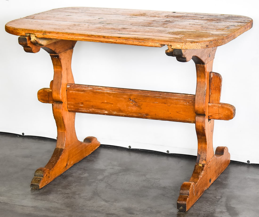 PRIMITIVE PINE WORK TABLE: An early 20th century pine work table with a trestle base. The table measures approx. 27" H x 49" W x 20" D.