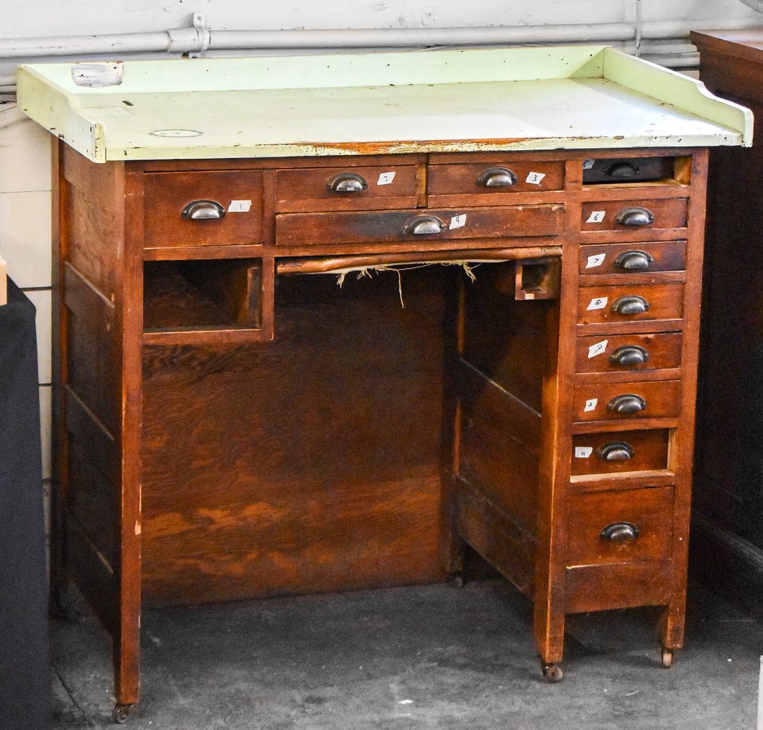 EARLY 20TH CENTURY WATCHMAKERS BENCH: This watchmakers work bench from the early 1900's, made of oak with a painted green top. It measures approx. 40" H x 45" W x 25" D.