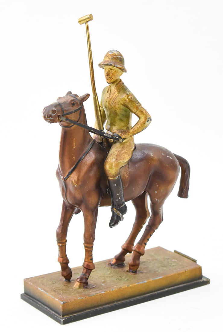 AUSTRIAN ART DECO COLD-PAINTED POLYCHROME FIGURAL POLO JOCKEY TABLE STRIKER: An Austrian Art Deco cold-painted polychrome figural table striker in the form of a mounted polo jockey with a removable polo mallet striker wand, circa 1910-1930s. The item measures 9" H x 5.5" W x