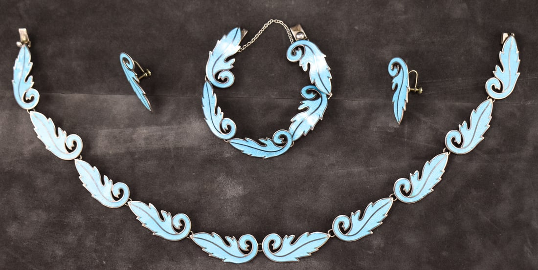 MIGUEL ARIAS FOR TAXCO, BLUE ENAMEL SCROLL LEAF STERLING SILVER JEWELRY SET: A set of Taxco blue enamel scroll leaf sterling silver jewelry designed by Miguel Arias, made circa mid-20th century. The set includes a necklace, bracelet, and pair of screw back earrings, all with
