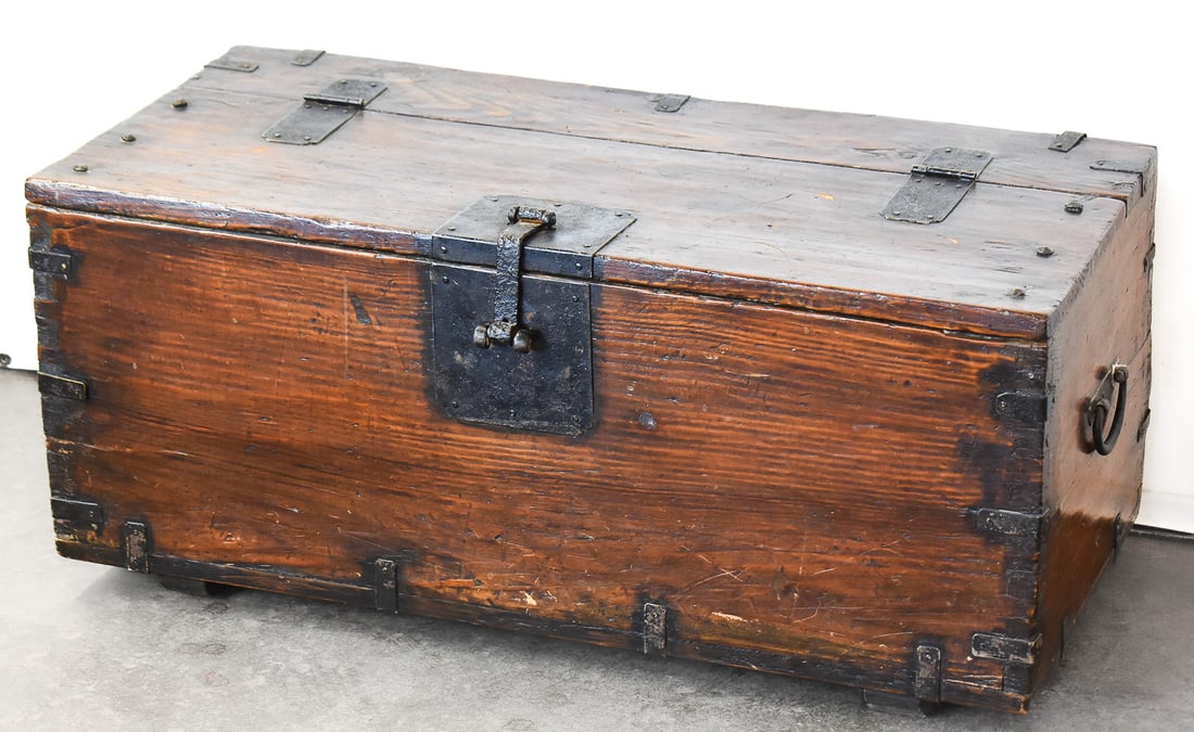 EARLY 19TH CENTURY KOREAN PINE MONEY CHEST: An early 19th century, Korean top-opening pine "money chest" with wrought iron hardware. It measures approx. 13" H x 31" W x 14" D.