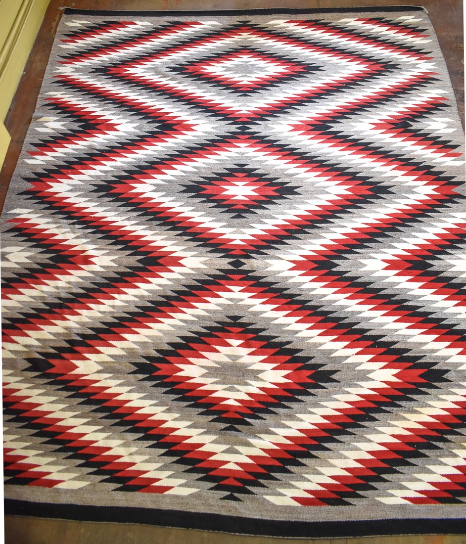 NAVAJO AREA RUG: This rug is made of hand spun and naturally dyed wool. It is then woven into the pattern known as "Eye Dazzler". Concentric serrated diamonds of "lightings" motifs in repeating rows creates this patte