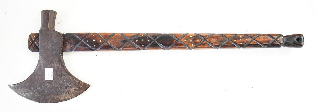 NORSE-STYLE BATTLE AXE: A Norse-style battle axe with a decorative cross carved wood handle, brass tacks, and an iron axe head marked "Handmade" and "1809". The axe measures approx. 21.5" H x 7" W x 0.5" D.