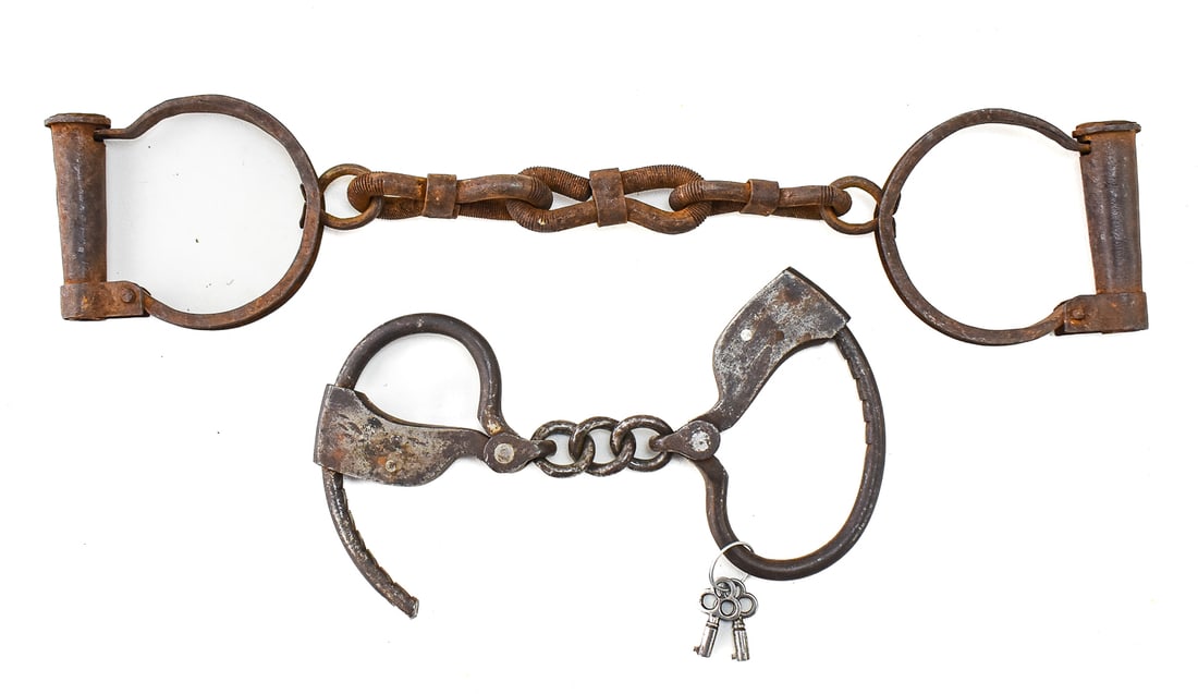 NINTEENTH CENTURY IRON HANDCUFFS & SHACKLES: This lot includes a pair of Towers double locking iron handcuffs (attr.) circa 1883 with keys included paired with primitive iron shackles constructed from metal with no makers mark or key. The box