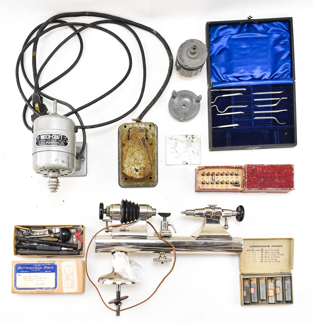WATCHMAKER'S LATHE & ACCESSORIES, C. & E. MARSHALL COMPANY: A watchmaker's lathe with an assortment of accessories including the foot pedal, chucks, carving bits, carborundum powder, and a vintage Watch-Craft 1/10 HP motor, made by C. & E. Marshall