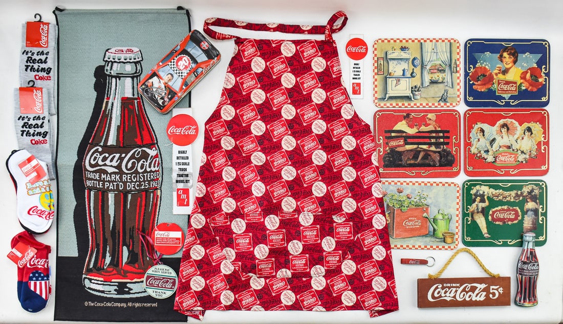 COLLECTION OF VINTAGE COCA-COLA PROMOTIONAL ADVERTISING: A collection of late 20th century Coca-Cola promotional items which includes, wall decor, socks, an apron and Nasar tin measuring 3" H x 8" W x 3" D.