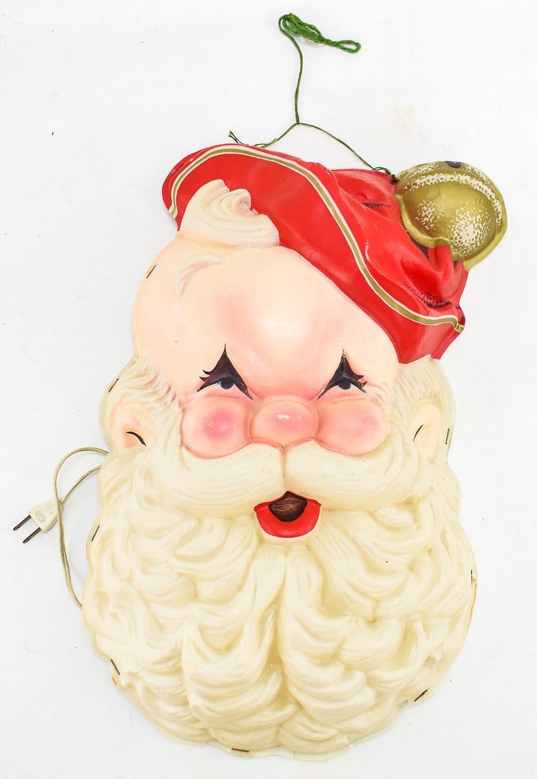 ROYALITE (ATTR.) LIGHTED SANTA CLAUS FACE: A Royalite (attributed) lighted plastic wall-hanging Santa Claus face, circa mid-late 20th century. The item measures 19" H, 12" W, 4.5" D.