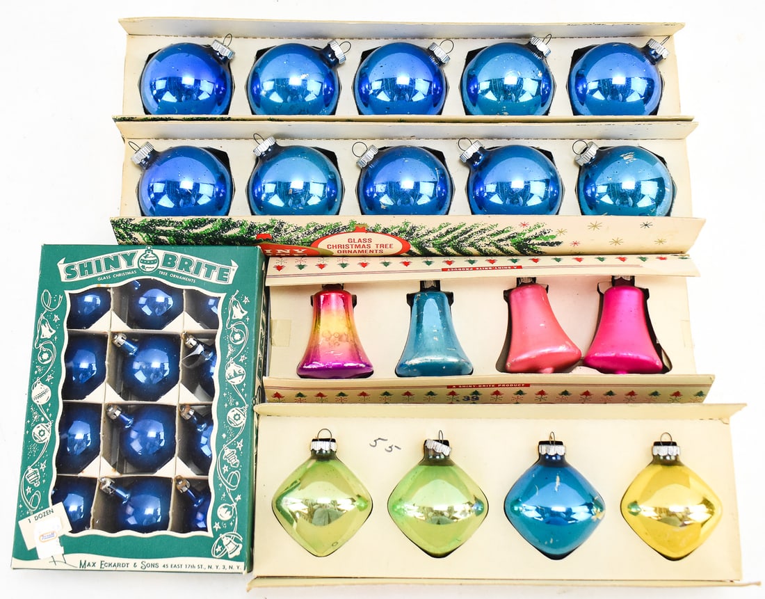 A TRIO OF BOXED SHINY BRITE ORNAMENTS: A trio of boxed Shiny Brite ornaments in assorted colors and shapes. The "bells" each measures 3" H x 2" W x 2" D.