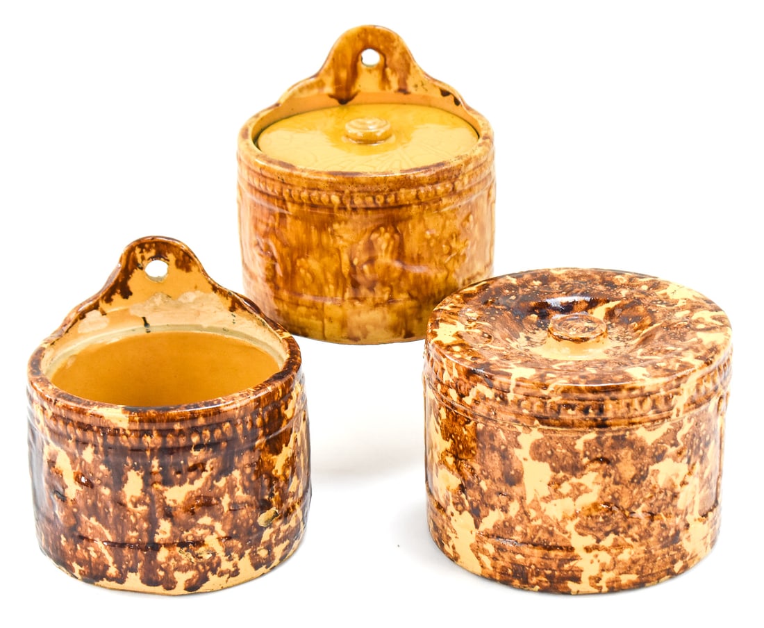 ROCKINGHAM-GLAZED SPONGE WARE SALT CELLARS AND COVERED JAR: This lot includes three Rockingham-glazed sponge ware items, from late 19th century: two hanging salt cellars and a covered jar. The largest item measures approx. 5" H x 6.5" W x 6.5" D.