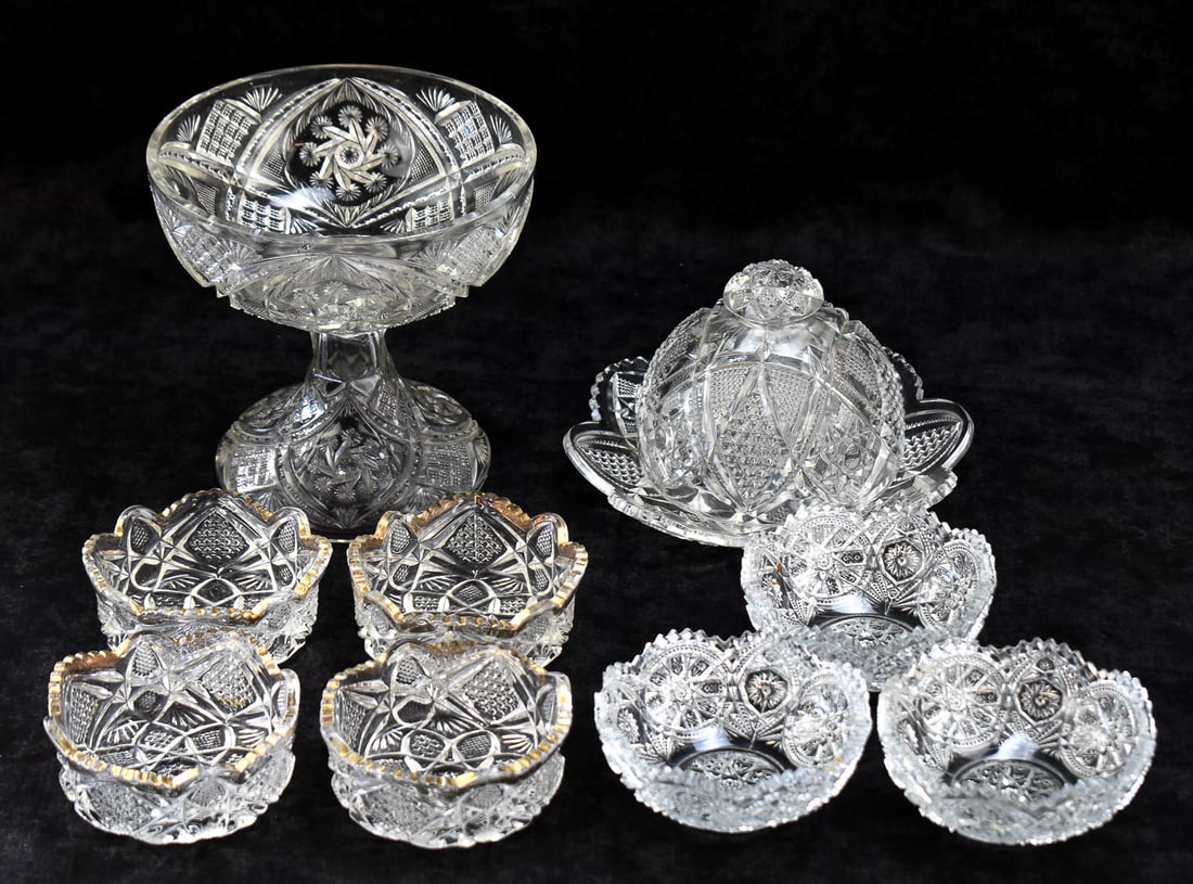 EAPG ASSORTMENT: COMPOTE, COVERED BUTTER DISH, AND DESSERT BOWLS: This lot includes the following Early American Pressed Glass items, from early 20th century: pedestal centerpiece compote, covered butter dish with underplate, and seven individual dessert bowls. The