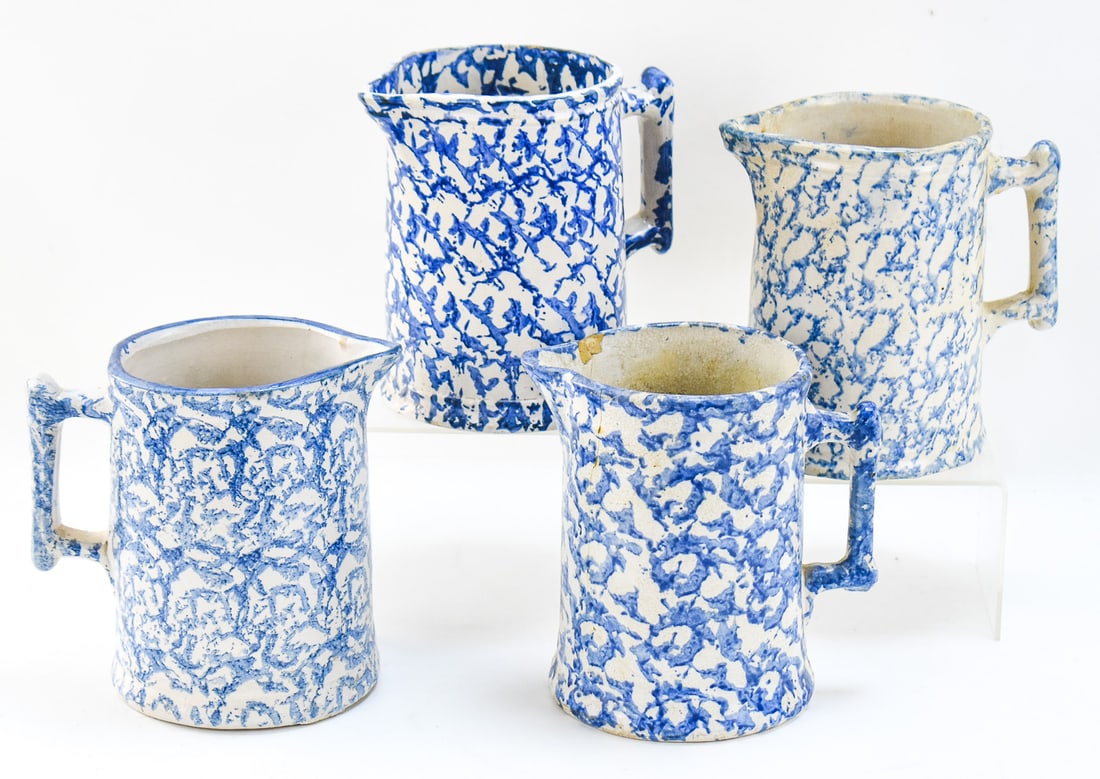 FOUR AMERICAN SPONGEWARE PITCHERS: This lot includes four American spongeware stoneware pitchers with handles, from late 19th-early 20th century. They each measure approx. 7" H x 5" W x 5" D.