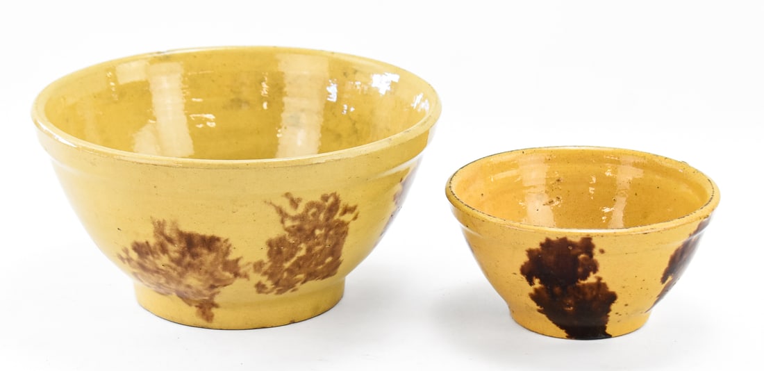 PAIR OF MID-ATLANTIC STYLE SPONGEWARE YELLOW WARE NESTING MIXING BOWLS: A pair of Mid-Atlantic style brown spongeware yellow ware nesting mixing bowls in two different sizes, from late 19th century. The largest item measures approx. 6" H x 11" W x 11" D.
