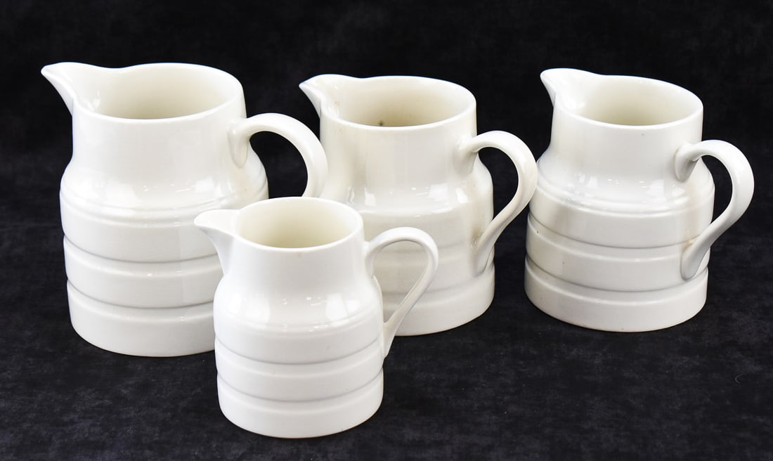 FOUR LORD NELSON POTTERY ENGLISH WHITE IRONSTONE PITCHERS: This lot includes four Lord Nelson Pottery (Staffordshire, England) white ironstone banded pitchers in various sizes, from late 20th century. The largest item measures approx. 7" H x 8" W x 5.5" D.