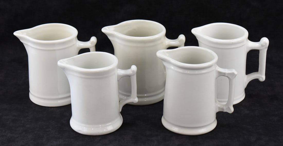 FIVE WHITE IRONSTONE MILK PITCHERS: WALKER CHINA, WEST END POTTERY, AND MORE