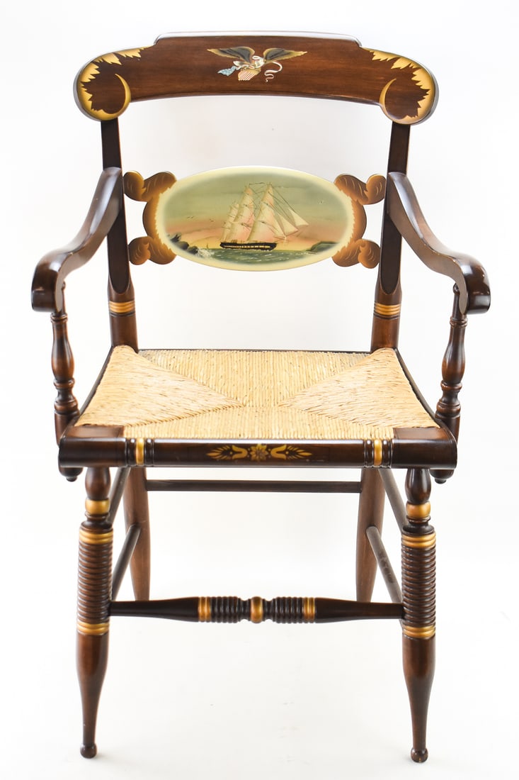 HITCHCOCK FURNITURE COMPANY LIMITED EDITION ARMCHAIR: A 1997 Hitchcock Furniture Company limited edition release of the U.S.S. Constitution "Old Ironsides" armchair No. 310/500 featuring a hand-painted nautical scene on the back rest and a woven rush