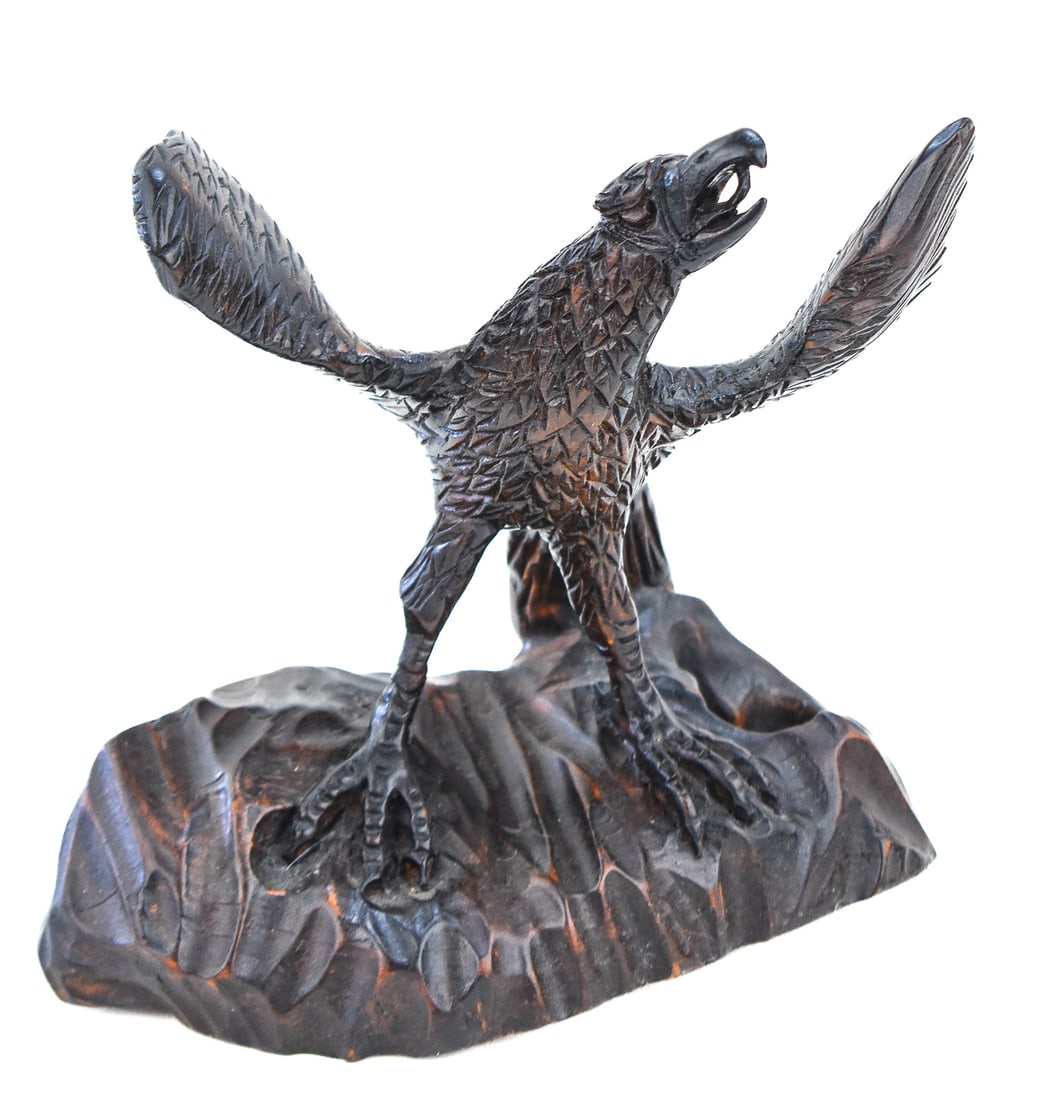 HANDCRAFTED FOLK ART SCULPTED EAGLE: This eagle was hand sculpted out of a soft wood in one solid piece. It was then painted black. Carving is from the mid 20th century and measures approx. 9" H x 9" W x 5" D.