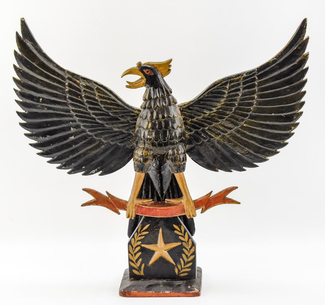 INDONESIAN POLYCHROME GARUDA PANCASILA SCULPTURE: An Indonesian polychrome carved wooden Garuda Pancasila sculpture featuring a motif for the first principle of Pancasila, from mid-late 20th century. The item measures approx. 21.5" H x 22.5" W x 6" D