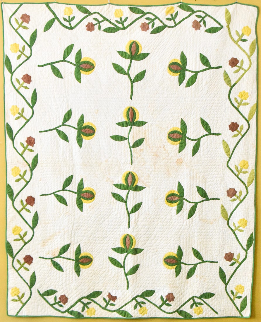 APPLIQUE QUILT WITH POMEGRANATE PATTERN: This quilt made circa 1850 features a pomegranate pattern done in yellow, green, and brown on a white background. It measures approx. 79" H x 68" W x 0.5" D.