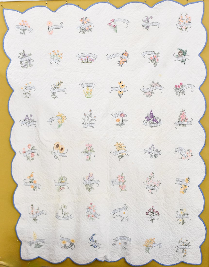 HAND EMBROIDERED STATE FLOWER QUILT: This quilt crafted circa 1930 features the lower 48 states and their flowers done in hand embroidery on a white background. the entire quilt measures approx. 96" H x 71" W x 0.5" D.
