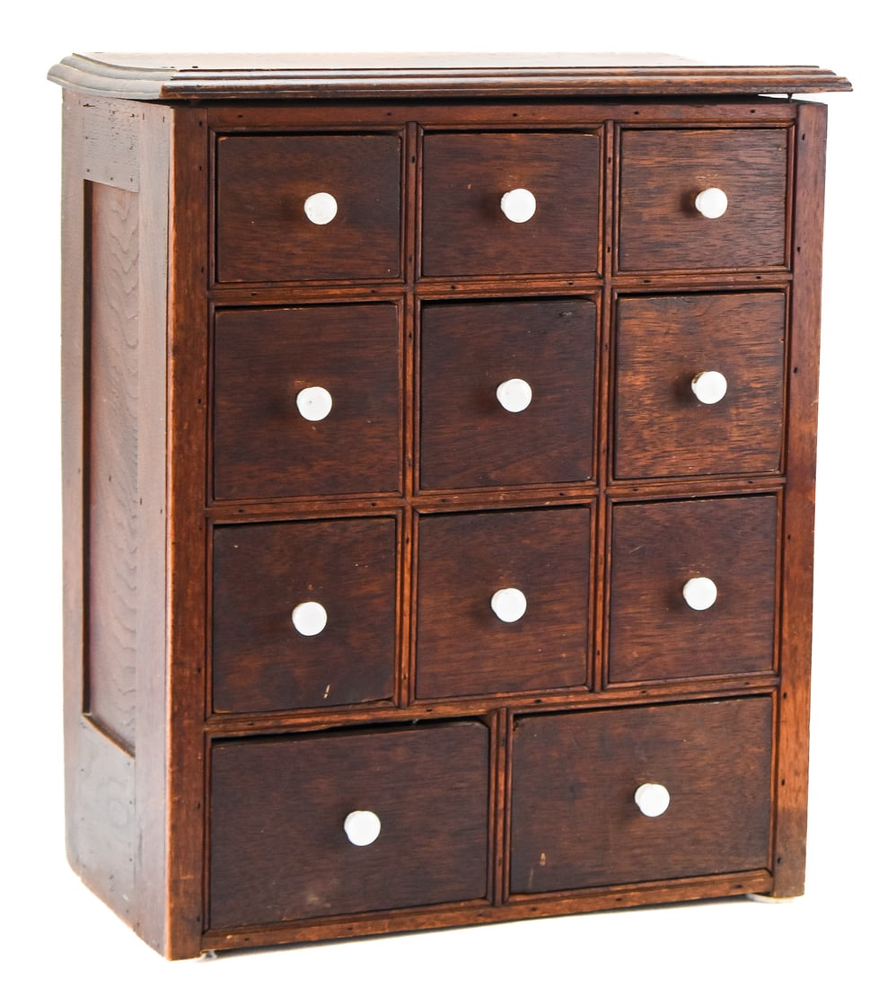 VICTORIAN OAK MULTI-DRAWER APOTHECARY CABINET: A Victorian oak eleven drawer counter-top apothecary cabinet with porcelain drawer pulls, from late 19th century. The item approx. measures 19" H x 16" W x 9" D.