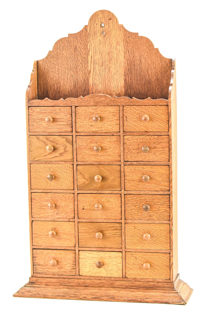 WOODEN WALL HANGING APOTHECARY CABINET: This apothecary cabinet features a hole to be hung on a wall as well as 18 drawers to hold herbs or spices. It measures approx. 31" H x 19" W x 5.5" D.