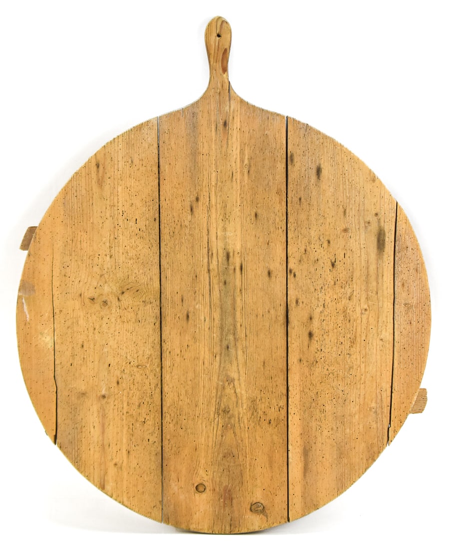 EXTRA-LARGE ROUND BREAD BOARD: An antique extra-large round plank-style bread board with handle. The board measures approx. 27.5" H x 23" W x 23" D.