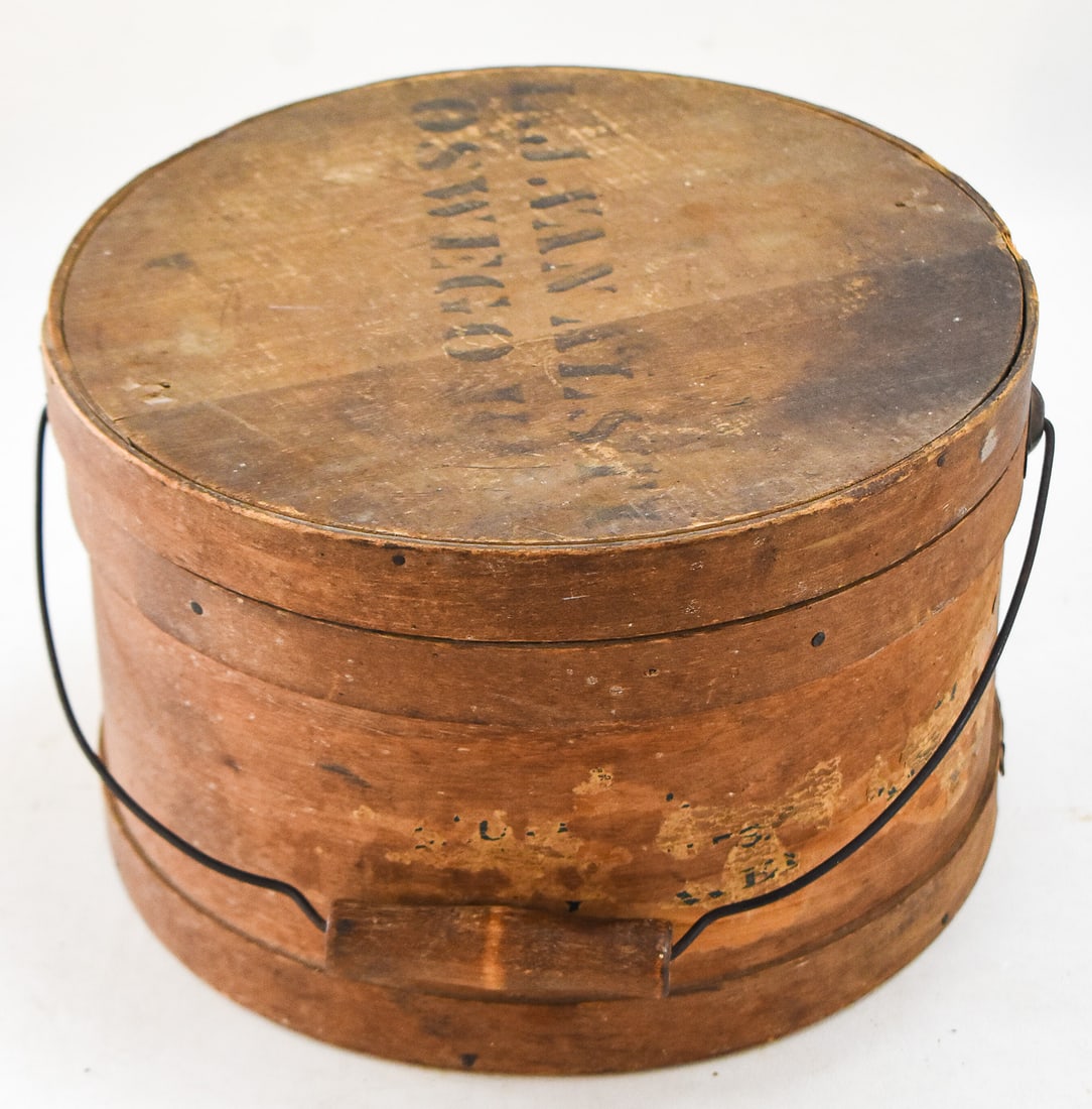 OSWEGO, NY BENTWOOD LIDDED BAIL-HANDLED PANTRY BOX: A bentwood lidded pantry box with a wire bail handle, from mid-late 19th century. This box has the location of Oswego, New York stamped on the top. The item measures approx. 5.5" H x 9.5" W x 9.5" D.
