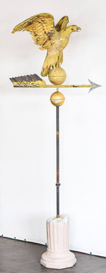 FULL BODIED GILT COPPER EAGLE WEATHERVANE: The weathervane is made of a molded hollow body copper eagle and an iron arrow to balance from the late 19th century. It was then gilded in gold. The base is a distressed pillar made of concrete. When
