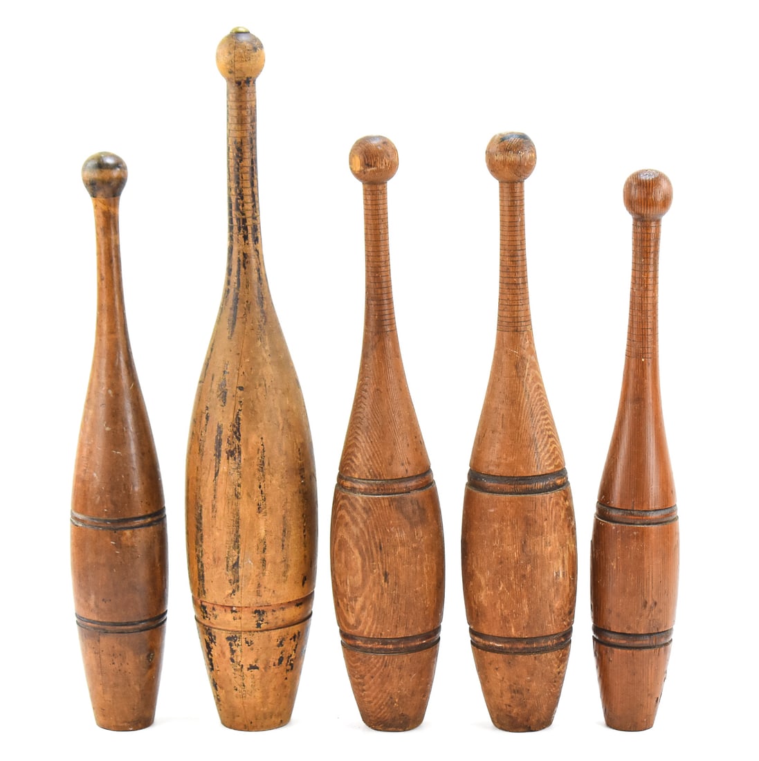 SET OF FIVE WOODEN INDIAN CLUBS: A set of five turn-of-the-century wooden Indian Clubs or juggling pins. The largest measures approx. 22" H x 4.5" W x 4.5" D.