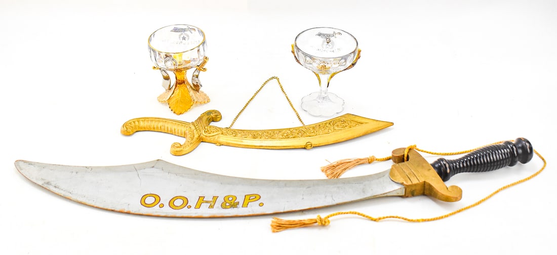 FRATERNAL ORDER ASSORMENT: This assortment consists of two O.O.H.&P scimitars and two Shriners commemorative glasses. The Oriental Order of Humility and Perfection is branch of the Odd Fellows. One scimitar is a novelty