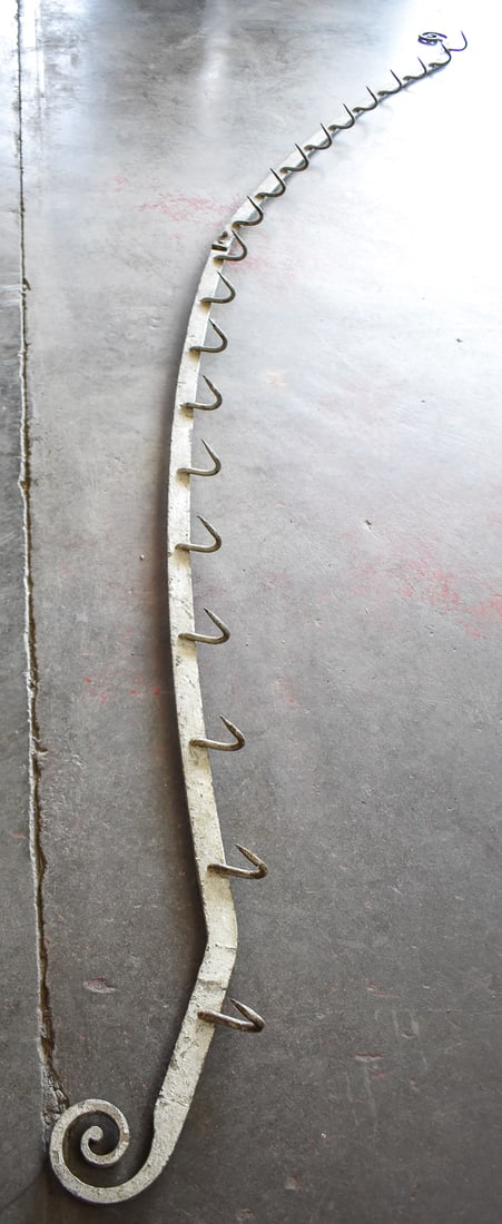 STEEL BUTCHER SHOP MEAT RACK: This steel meat rack was hand forged by a blacksmith in the late 19th century. This rack has 20 hooks and measures approx. 11" H x 108" W 3" D.