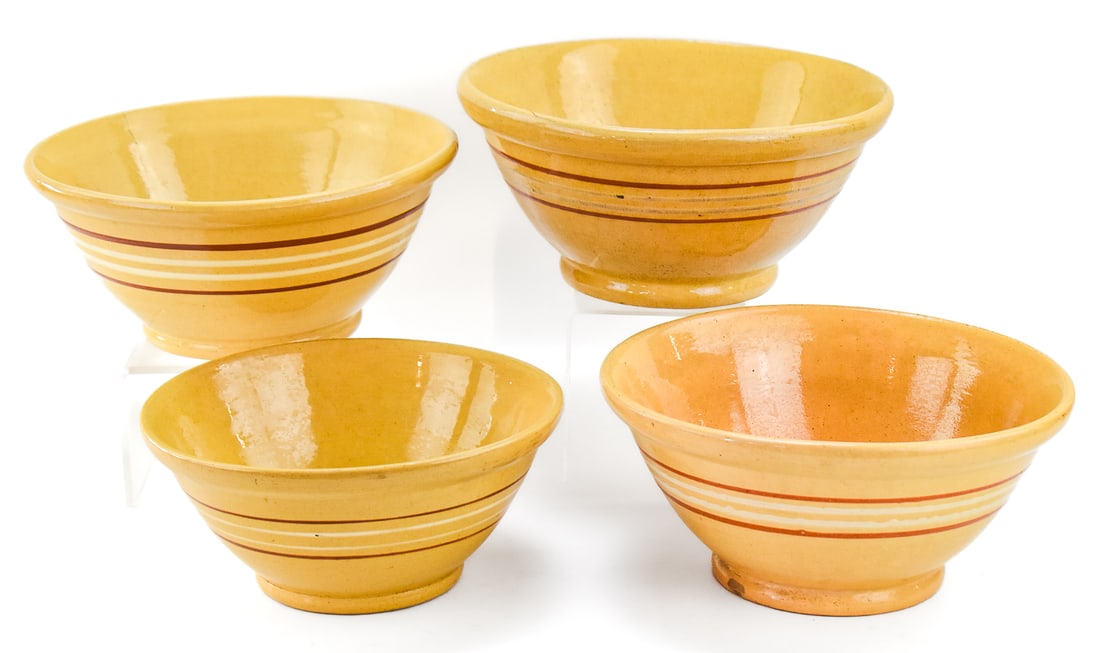 ASSORTMENT OF FOUR LARGE BANDED YELLOW WARE BOWLS: This lot includes four assorted large yellow ware bowls decorated with multi-colored banding, from the early-mid 20th century. The largest bowl measures approximately 5.5" H x 11.5" W x 11.5" D.