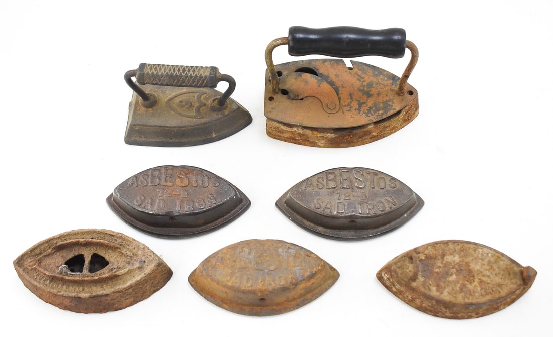 COLLECTION OF VARIOUS CAST IRON SAD IRONS: This collection includes eight various cast iron sad irons, circa 1900, with three labeled Asbestos 72-B. The largest of the eight measures approx. 8" H x 4" W x 2" D.