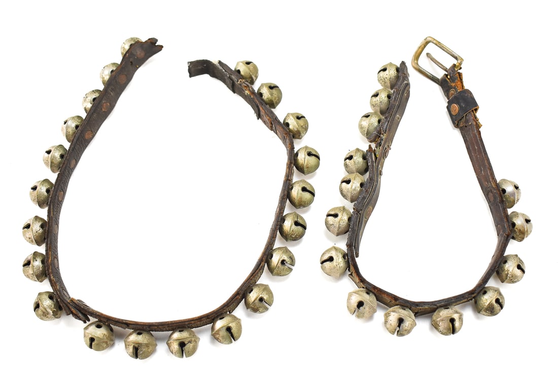 EQUESTRIAN SLEIGH BELL LEATHER STRAP: An equestrian leather sleigh bell strap with approximately 35 cast-metal crotal bells, from the late 19th to early 20th century. The largest section measures approx. 35" H x 1" W x 1.5" D.