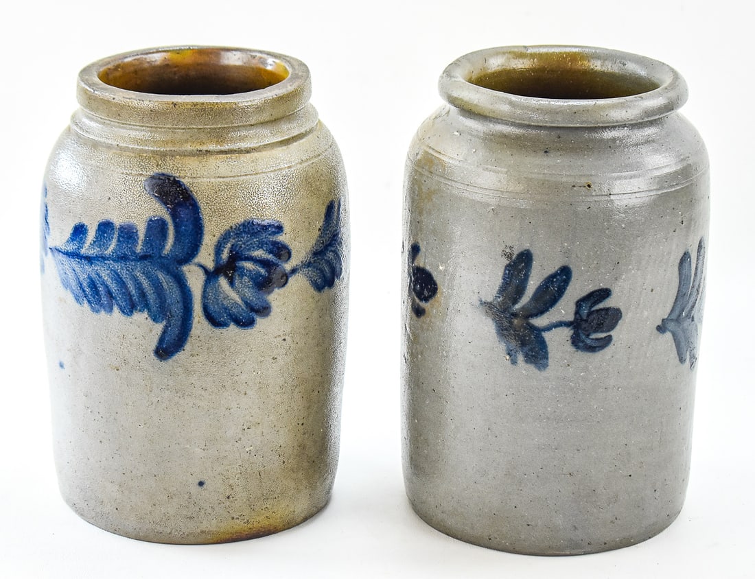 TWO MID-ATLANTIC STYLE FLORAL COBALT CROCKS: This lot includes two unmarked Mid-Atlantic style cobalt floral-designed crocks. One features a triple tulip design while the other has four simpler floral designs. Each measures approx. 10.5" H x