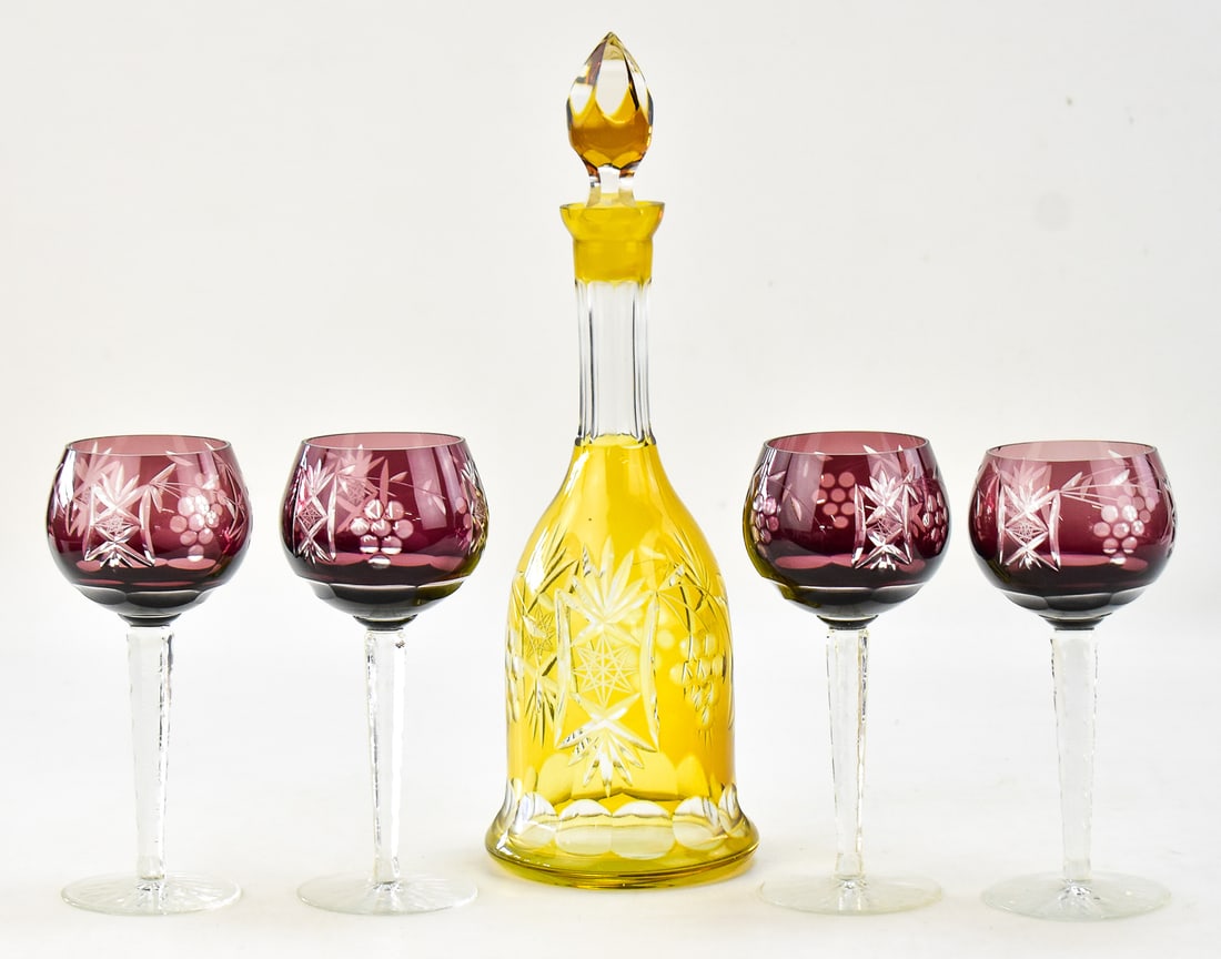 BOHEMIAN TOPAZ CUT-TO-CLEAR GLASS DECANTER AND FOUR AMETHYST HOCK GLASSES: This lot includes a Bohemian topaz cut-to-clear glass decanter with four amethyst hock glasses, circa mid to late 20th century. The largest item measures 12" H x 4.5" W x 4.5" D.