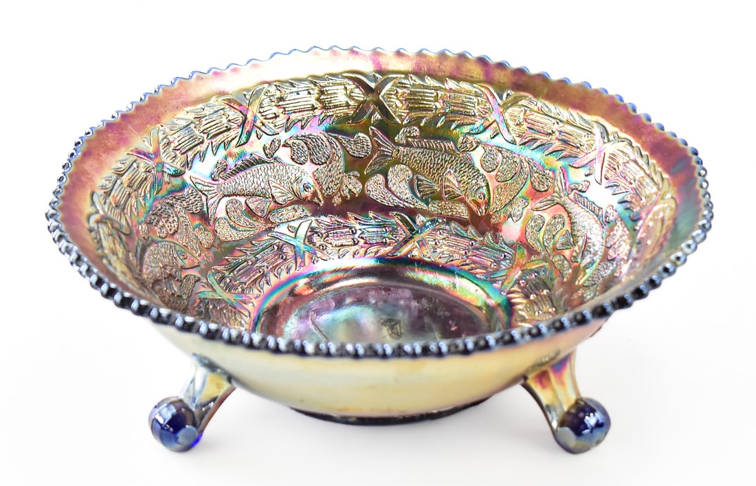 FENTON ART GLASS "LITTLE FISHES" CARNIVAL GLASS BOWL: A Fenton Art Glass (Williamstown, W. VA) "Little Fishes" amethyst carnival glass bowl, circa 1915-1921. The item measures approximately 3.5" H x 9" W x 9" D.