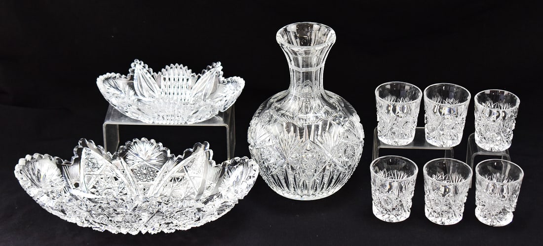 AMERICAN BRILLIANT PERIOD CUT GLASS ASSORTMENT: LIBBEY, PITKIN & BROOKS: An assortment of American Brilliant Period glassware: Pitkin & Brooks marked sawtooth rim tray, Libbey marked sawtooth rim tray, a water carafe, and a set of six shot glasses. The carafe measures 