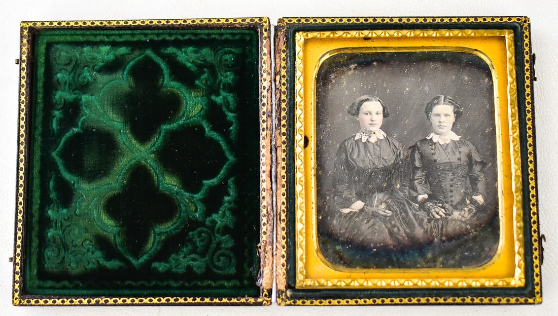 CASED DAGUERREOTYPE OF TWO WOMEN IN BLACK: A cased daguerreotype depicting two women in Victorian black dresses, mid-19th century. The photo in the case measures approximately 3.5" H x 3" W x 1" D.