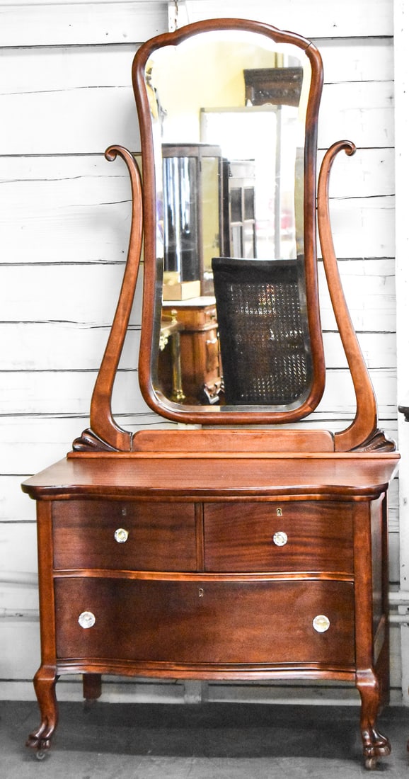 MAHOGANY SERPENTINE FRONT PRINCESS VANITY DRESSER: Dresser has flame mahogany veneer, serpentine curved drawers on the front, glass knobs and claw feet. Dresser measures approximately 72" H x 36" W x 22" D.