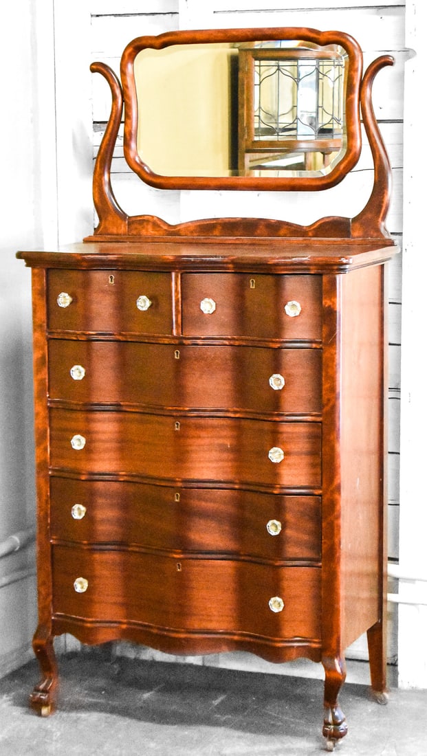 CHIPPENDALE REVIVAL MAHOGANY HIGHBOY: A Chippendale Revival style flame mahogany highboy with six drawers and a tilt-top mirror, turn of the 19th century. The item measures approximately 68" H x 34" W x 20" D.
