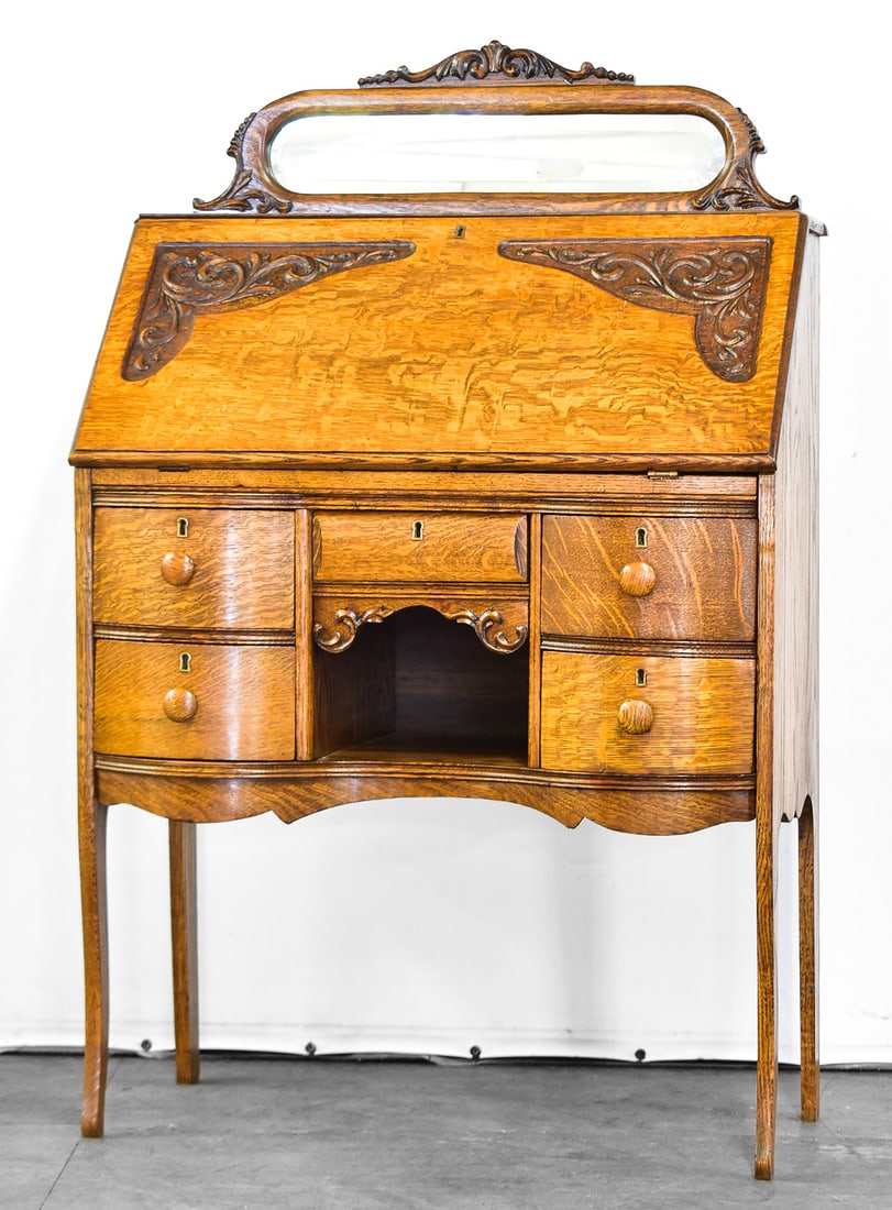TIGER OAK SLANT FRONT SECRETARY DESK: This piece is an American Victorian desk from circa late 19th century. It is crafted from quarter sawn white oak and measures 48" H x 30.5" W x 17.5" D.