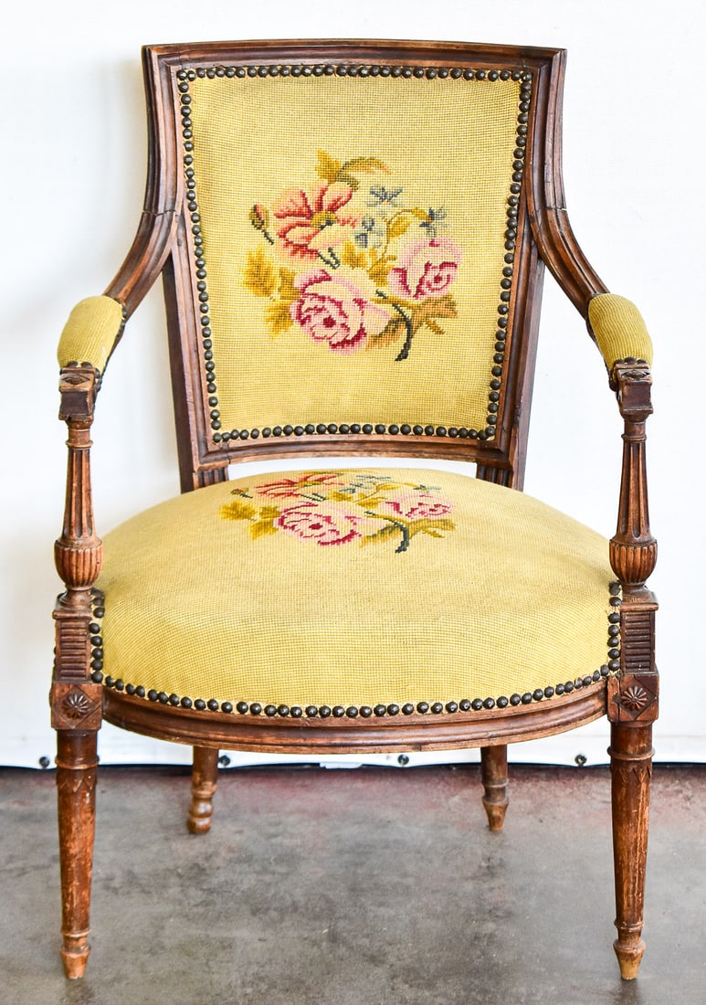 FRENCH DIRECTOIRE REVIVAL NEEDLEPOINT FAUTEUIL: A French Directoire Revival style floral-upholstered walnut fauteuil, circa mid-late 19th century. The chair measures approximately 33" H x 21.5" W x 19" D.