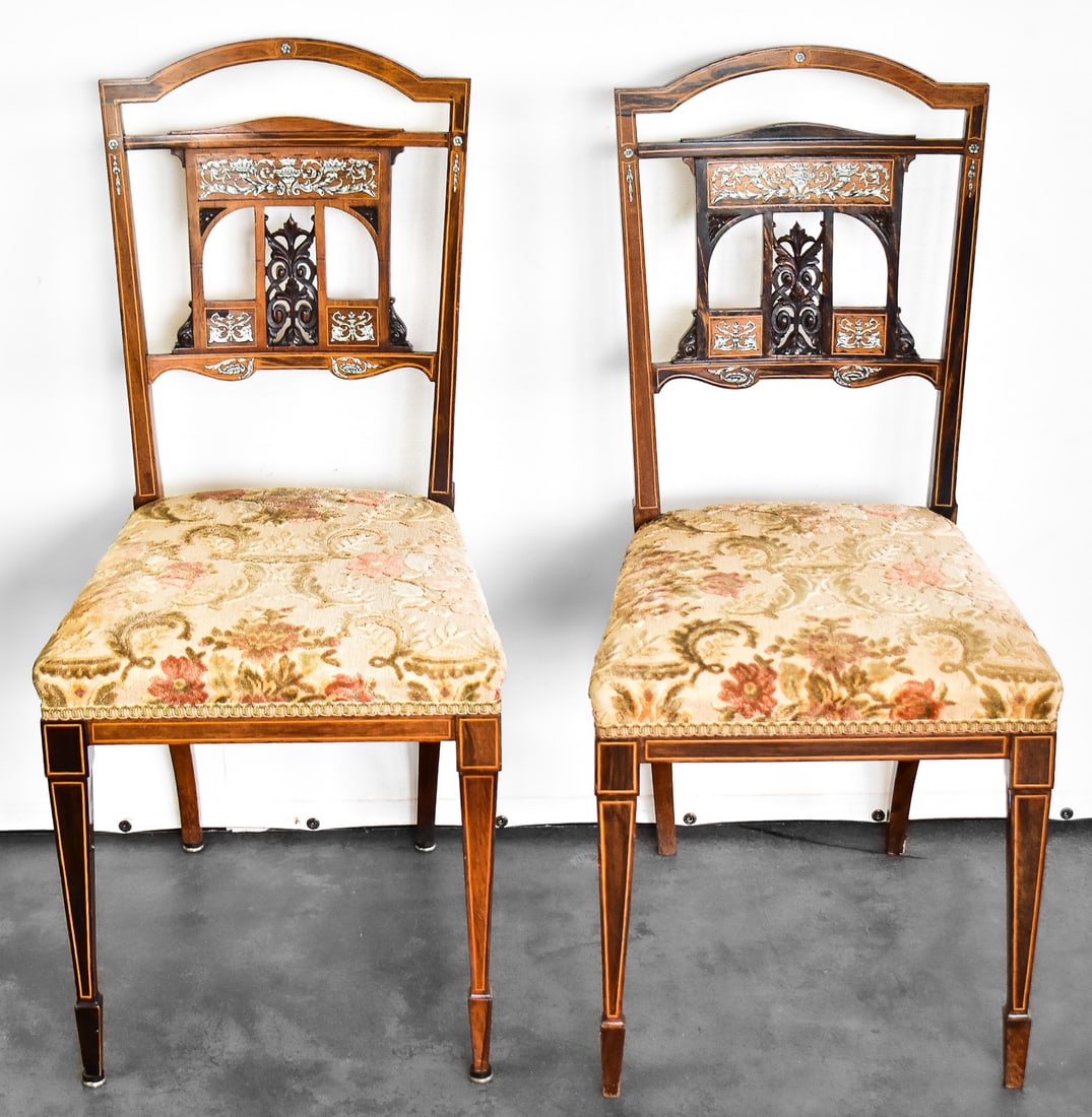 EDWARDIAN MARQUETRY INLAID PARLOR CHAIR PAIR: Both marquetry inlaid chairs feature a floral and scroll carved splat back with a floral pattern upholstery. Each chair measures approx. 35" H x 17" W x 16" D.