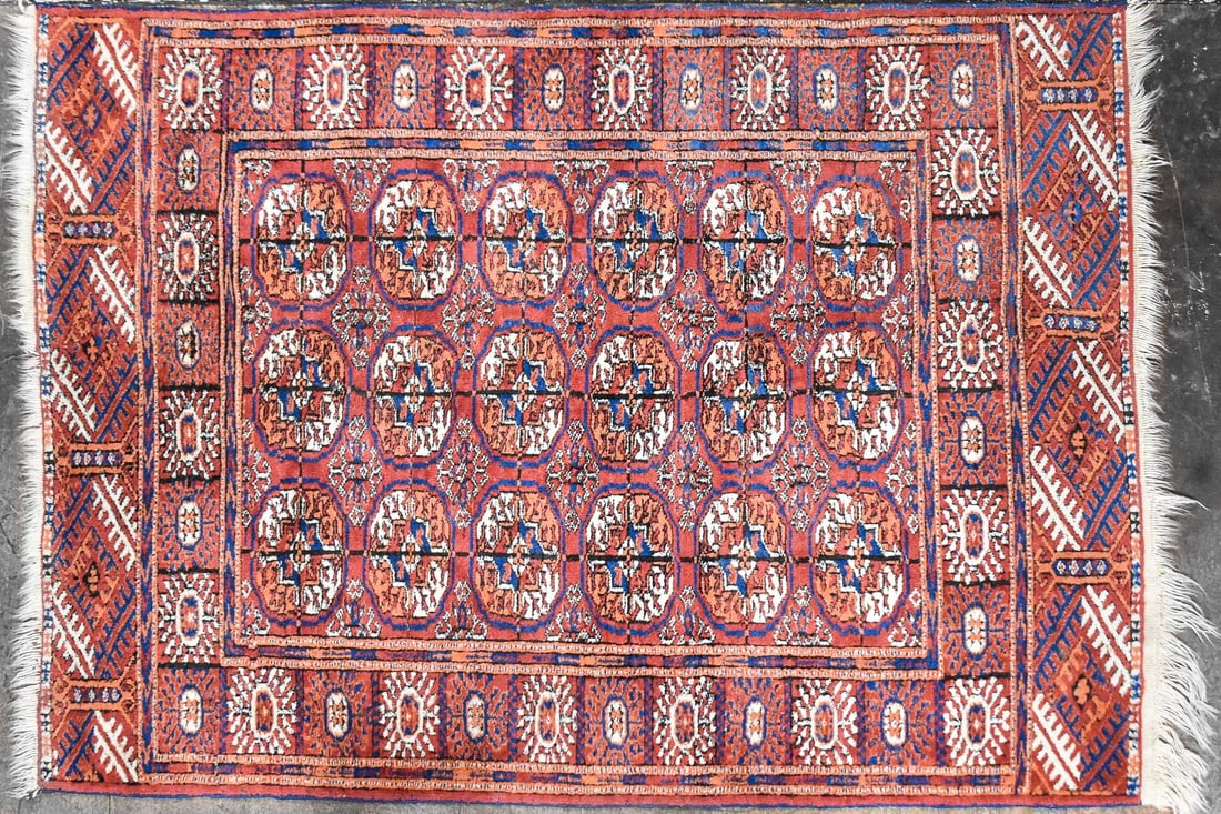 PERSIAN SMALL WOOL RUG: A Persian wool area rug with a red field accented with blue and beige coloring and geometric patterns. The rug measures approximately 60" L x 42" W x 0.5" D .