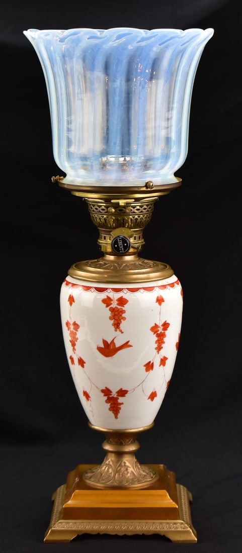 LIBERTY BURNER PARLOR OIL LAMP: The lamp body is hand painted ceramic, Liberty brand wick burner and still set to burn oil. The lamp measures approximately 21" H x 8" W x 8" D.