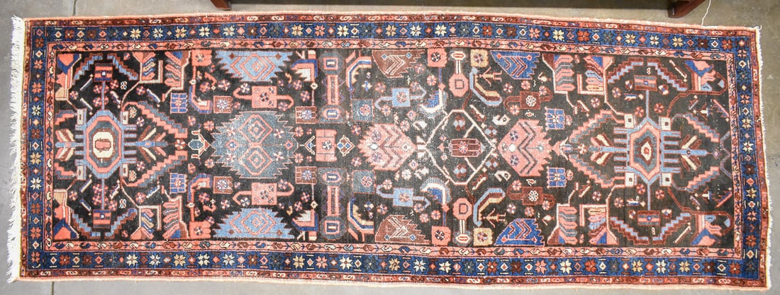 PERSIAN HAMADAN WOOL RUNNER: An antique Persian Hamadan wool runner with a deep blue floral border, and a geometric figural field with deep red, light blue, and pink coloring. The rug measures approximately 116" L x 41" W x 0.5"