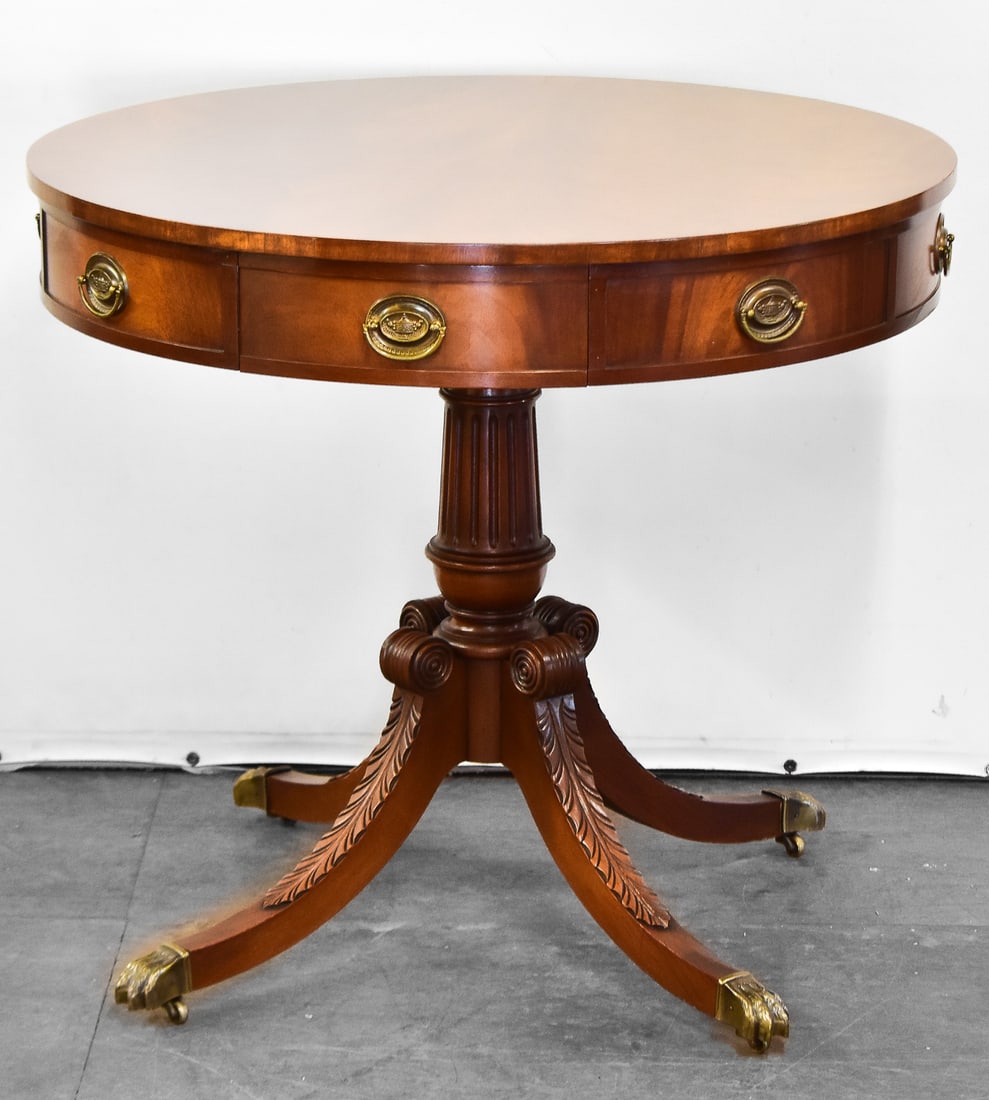 DUNCAN PHYFE STYLE DRUM TABLE: These tables were crafted in the 1940s-1950s as reproductions of the popular Federal style made famous by cabinet maker Duncan Phyfe. This table is made of mahogany wood with brass hardware and claw