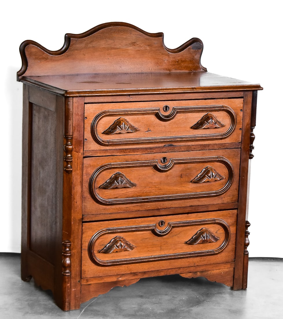 EASTLAKE STYLE CHEST OF DRAWERS: This chest of drawers is craved from walnut wood circa late 19th century. Dresser measures approximately 35.5" H x 29" W x 16" D.